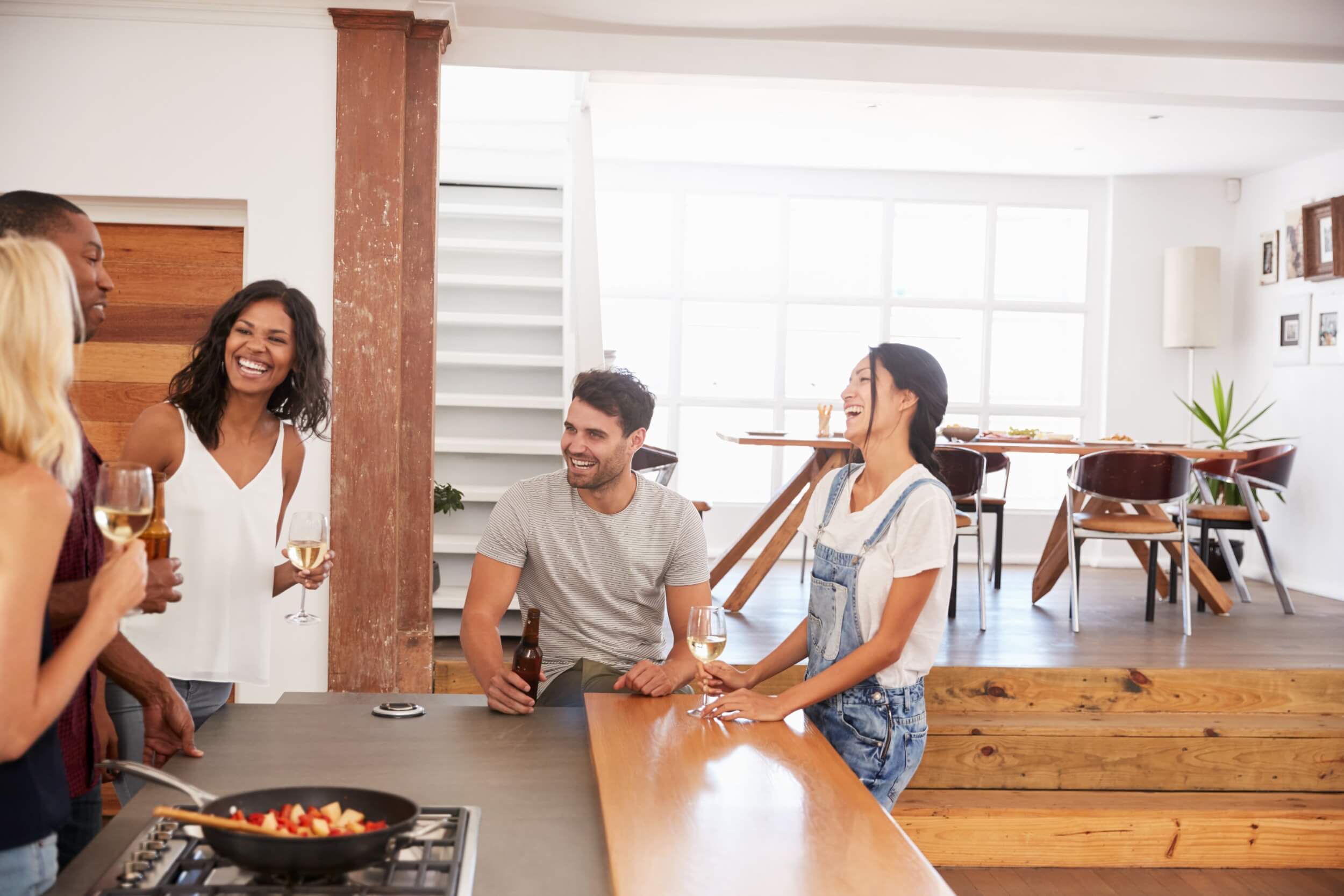 Des personnes discutent et cuisinent dans une cuisine partagée lumineuse